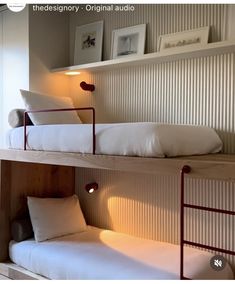 two bunk beds with white sheets and pillows in a room that looks like it has been built into the wall