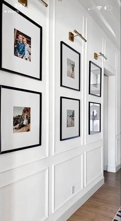 a white wall with black and white pictures hanging on it's sides, along with wooden flooring