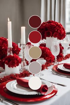 the table is set with red and white flowers, silverware, candles, and napkins