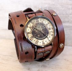 ✅CUCKOO NEST ART STUDIO DESIGN Men's leather watch made with veg tanned leather, completely handmade. The leather cuff is 2 1/2 inches wide. Item includes a vintage style Cuckoo Nest Art Studio™ watch face and is removable and interchangeable. Heavy duty buckle provides closure. ✅THIS WATCH IS MADE TO ORDER, please use the following measuring technique to determine your wrist size: MEASURE YOUR WRIST over and around the wrist bone using a measuring tape, do not add to it. You want to measure is Leather Steampunk Watches, Steampunk Leather Strap Watch, Steampunk Style Watch With Subdials As Gift, Steampunk Watches With Leather Strap As Gift, Steampunk Style Watch With Leather Strap As A Gift, Steampunk Leather Bracelet Perfect As A Gift, Steampunk Leather Bracelet As A Gift, Vintage Leather Strap Bracelet As Gift, Adjustable Steampunk Brown Watch