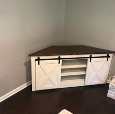 a white entertainment center with sliding doors and shelves