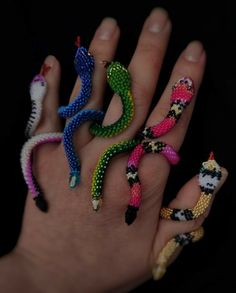 four different colored beads on the palm of a person's hand with their fingers