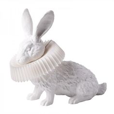 a white rabbit figurine with an origami collar around its neck