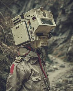 a man with a camera on his head in front of some rocks and trees,