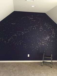 an empty room with a ladder in front of the wall and stars painted on it