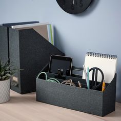 a desk with a phone, pen holder and other office supplies