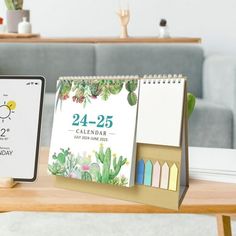 two calendars sitting on top of a wooden table next to a tabletop clock