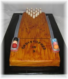 a cake that is shaped like a bowling board with pins and balls on the top