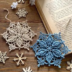 crocheted snowflakes are laying next to an open book