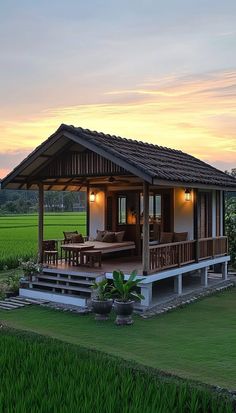 a small wooden house sitting on top of a lush green field next to a lush green field