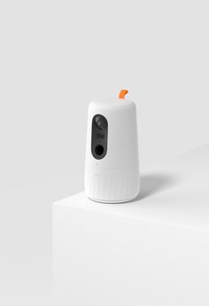 an orange and white object sitting on top of a white surface next to a wall