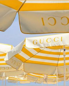 many yellow and white umbrellas with the word gucci on them