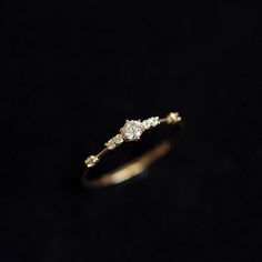 a gold ring with three diamonds on it's side, against a black background