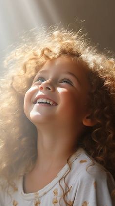 Portrait en contre-plongée d'une jeune enfant souriante avec des cheveux bouclés blonds illuminés par une douce lumière naturelle, portant un haut blanc à motifs, son visage exprimant une joie pure