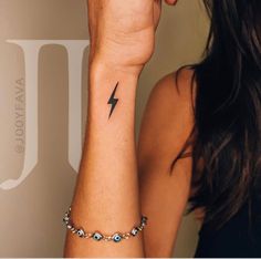 a woman's arm with a lightning tattoo on the left side of her wrist