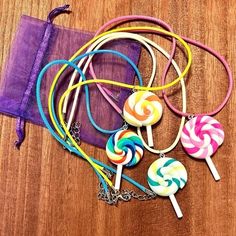 several lollipops on a wooden table next to a purple bag and chain