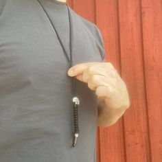 a man wearing a necklace with a screwdriver attached to it