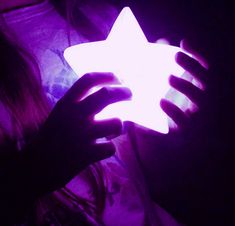 a person holding a glowing star in their hands