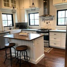 a large kitchen with white cabinets and wooden floors