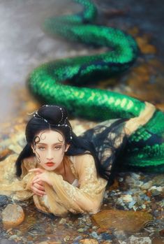 a doll is laying on the ground next to a snake