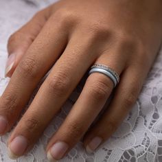 a close up of a person's hand with a wedding ring on their finger