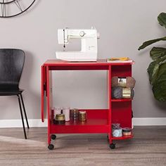 a sewing machine sitting on top of a red shelf next to a chair and clock