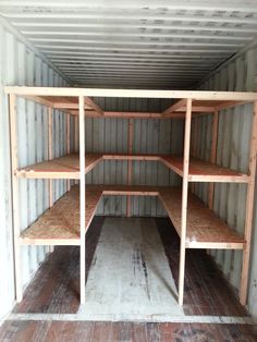 an empty storage room with wooden shelves in it