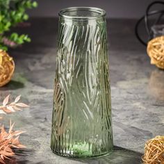 a green glass vase sitting on top of a table