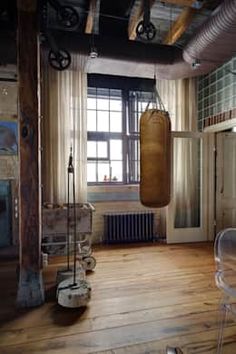 an instagram photo with a boxing bag hanging from it's ceiling and windows