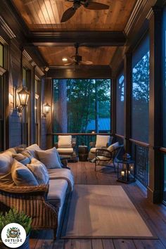 an outdoor covered porch with wicker furniture and ceiling fan at night, lit by lanterns