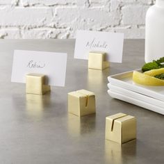 place cards are placed next to lemons and mint on a table with a white vase