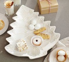 an assortment of desserts and pastries on a tray next to two glasses of milk