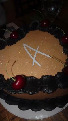 a cake with chocolate frosting and cherries on it, decorated with the letter q