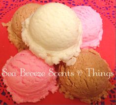 three scoops of ice cream sitting on top of a red doily next to each other