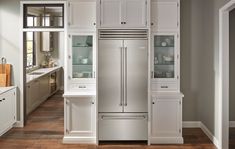 a yellow refrigerator freezer sitting inside of a kitchen next to white cabinets and drawers