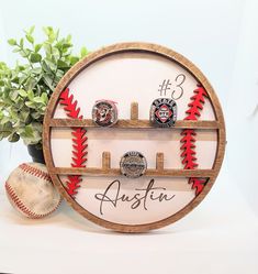 a baseball and some rings on a shelf with the name austen written in it