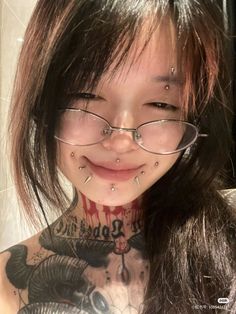 a woman with glasses and piercings on her neck