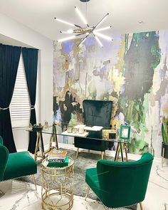 a living room filled with green chairs and a painting on the wall behind two windows