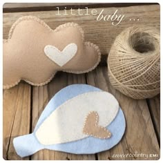 two little baby pillows sitting on top of a wooden table next to yarn and twine