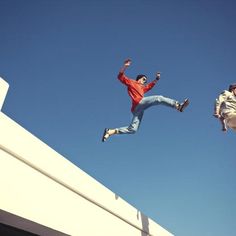 two men jumping in the air with their feet up and one man on his skateboard