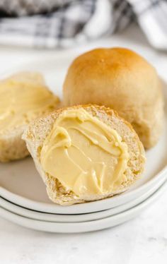 two rolls with peanut butter on them are sitting on a plate next to another roll