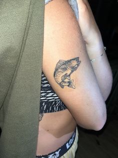 a woman with a fish tattoo on her arm