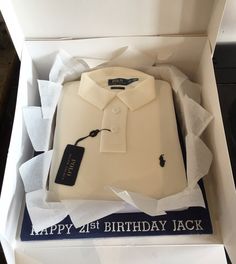 a birthday cake in the shape of a polo shirt with a name tag on it