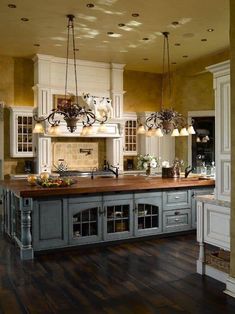 a large kitchen with an island in the middle and lots of lights hanging from the ceiling