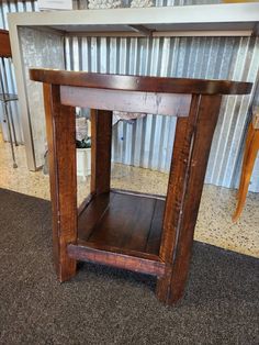 a small wooden table sitting on top of a carpeted floor