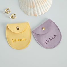 two bibs with name written on them next to a seashell and other accessories