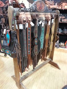 a display case filled with lots of different types of handbags and purses on wooden stands