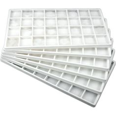 four white trays are stacked on top of each other