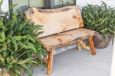 a wooden bench sitting next to potted plants