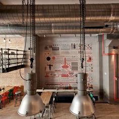 an industrial style kitchen and dining area with exposed pipes, pendant lights, and wooden tables